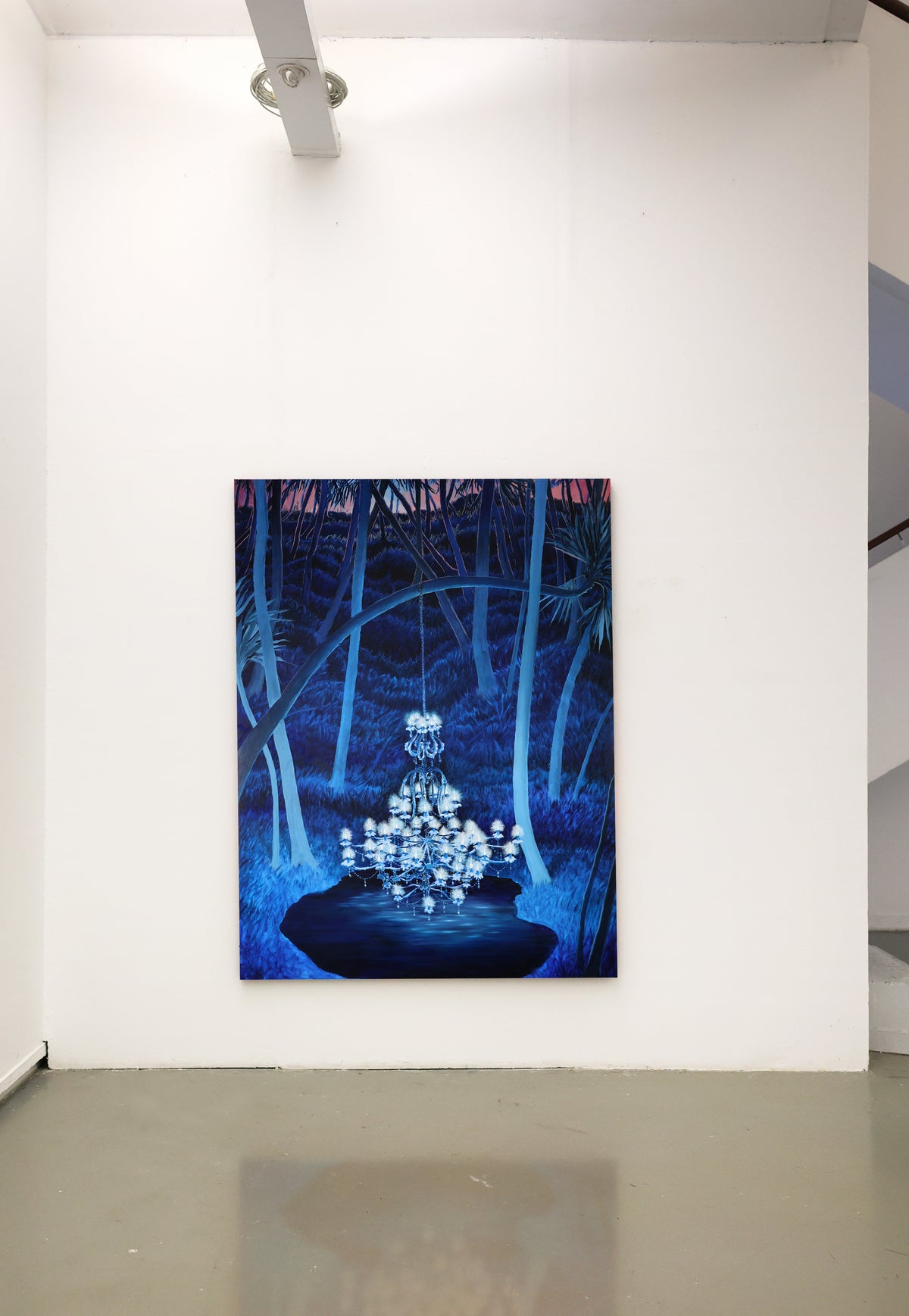 
Framed artwork of a chandelier in a forest setting on a white wall.